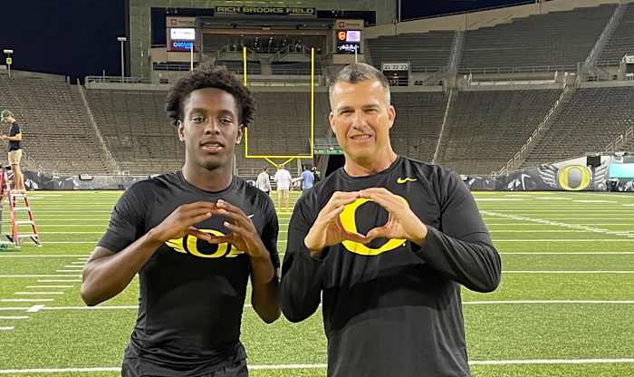 Florence throws up the O with Mario Cristobal following Oregon's Saturday Night Live camp.